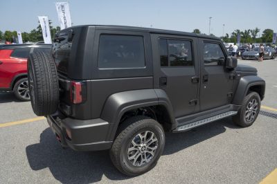 Boxy SUV rear side with mounted spare tire and matte black finish