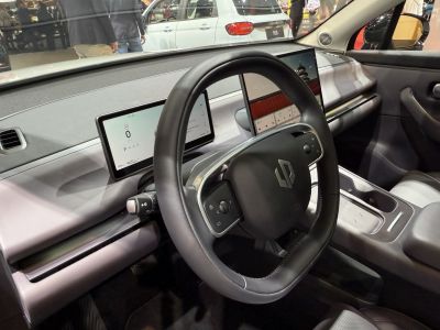 Dual digital screens and futuristic steering wheel in car interior