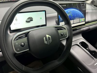 Steering wheel with integrated controls and dual digital display screens inside a modern vehicle