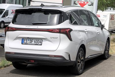 Rear view of white vehicle with sleek LED taillights and rear hatch.