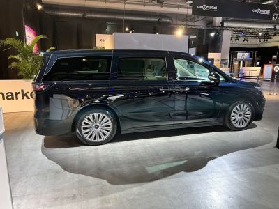 Modern black minivan side view with rear spoiler and alloy wheels