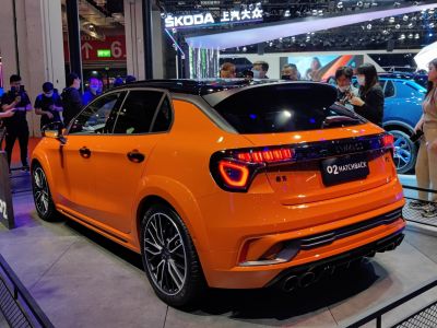 Rear side view of vibrant orange hatchback with quad exhaust and LED taillights