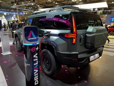 Electric SUV charging at public EV station with modern angular design and rear LED lights