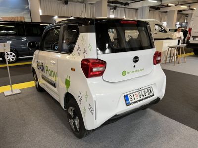 Compact electric microcar rear view with black roof and tail lights