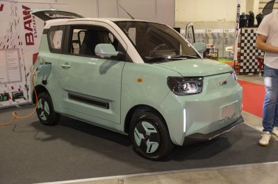 Compact electric vehicle with geometric wheels charging indoors.