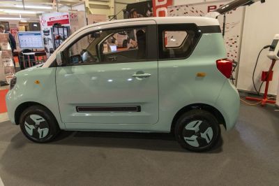 Compact microcar side profile with two-tone body and unique window design.