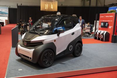 Compact electric microcar with aerodynamic black and white design and small wheels