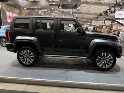 Matte black SUV with four doors and distinctive alloy wheels.
