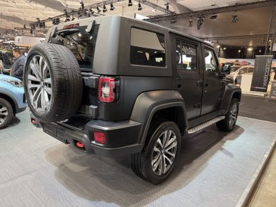 Matte black off-road SUV with rear spare wheel and modern taillights