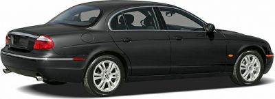 Rear-side view of classic luxury sedan with smooth curves and alloy wheels