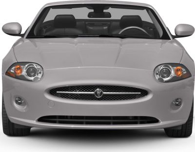 Front view showing round headlights and mesh grille with badge.
