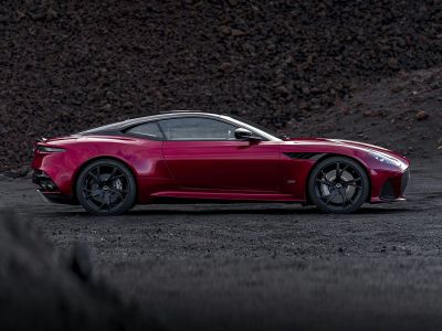 Sleek luxury coupe side profile with black wheels and aerodynamic detailing.