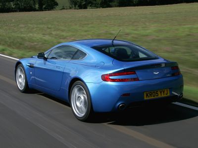 Blue luxury sports coupe rear side with dual exhaust and sleek aerodynamic design.