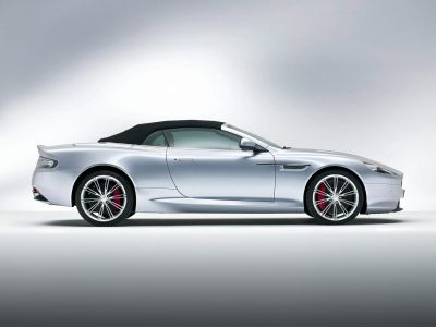 Silver convertible with soft top and alloy wheels, side profile view