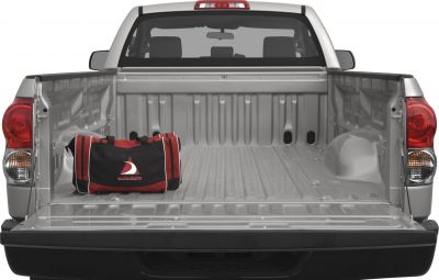 Open truck bed of a pickup with rear lights and red bag