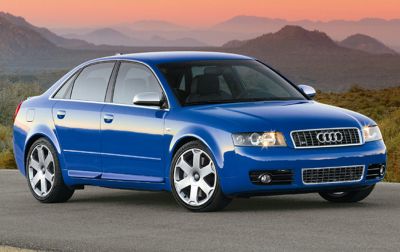Front side view of blue sedan showing headlights and alloy wheels