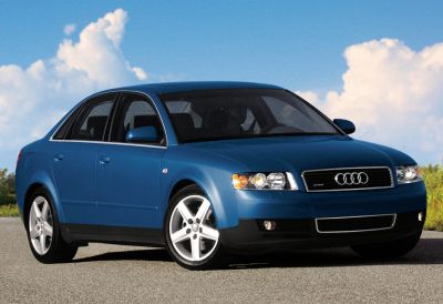 Blue sedan with distinctive headlights and grille on road