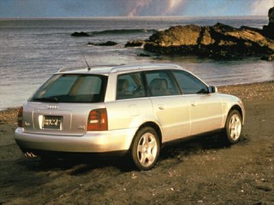 Silver station wagon rear view with roof rails and alloy wheels.