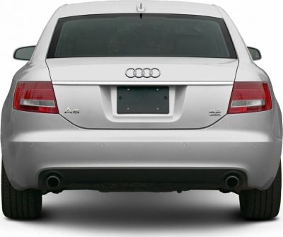 Silver sedan rear with tail lights, dual exhausts, and rear window