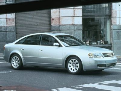 Silver sedan front-side profile with alloy wheels in urban environment