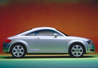 Side profile of a sleek two-door sports coupe with rounded roofline and smooth design.