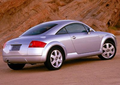Rear and side profile of a silver coupe with sporty design and alloy wheels.