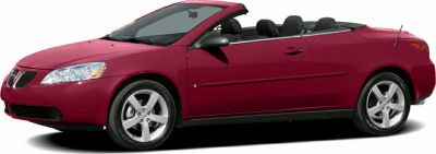 Red two-door convertible with soft top and alloy wheels side view
