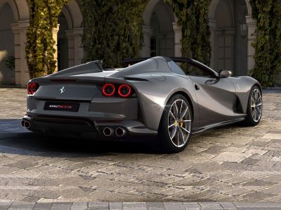 Rear and side view of convertible sports car with quad exhausts and round tail lights