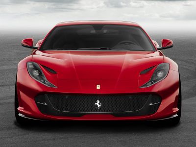 Red sports coupe with aerodynamic vents and honeycomb grille front view