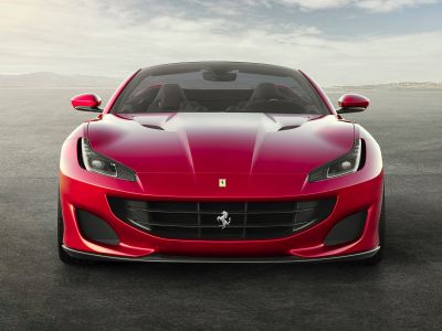 Front view of red convertible sports car with aggressive LED headlights and aerodynamics
