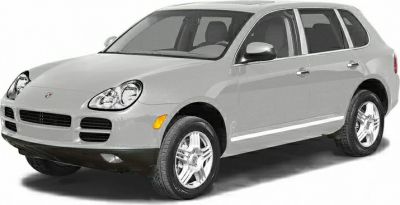 Front-side view of Porsche SUV with iconic headlights and alloy wheels.