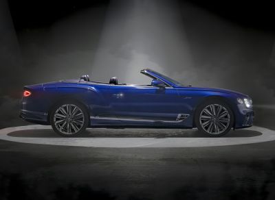 Side view of a luxury convertible with open roof and distinctive wheels