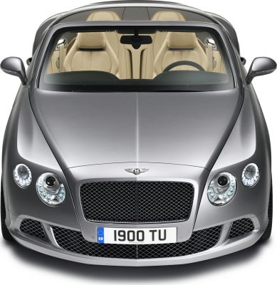 Front grille, round headlamps, and beige leather interior of luxury convertible