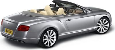 Silver convertible luxury vehicle with beige interior, rear side view