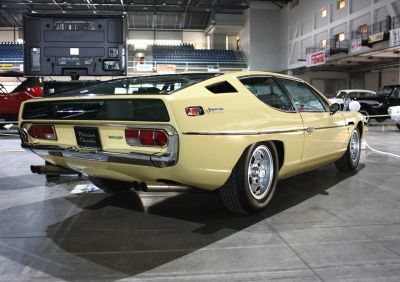 Yellow vintage sports car rear side with classic taillights and alloy wheels