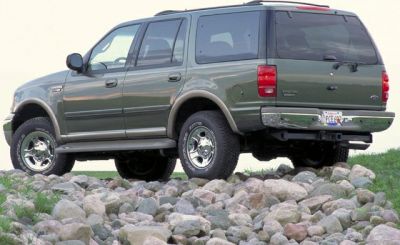 Rugged SUV rear side view on rocky terrain