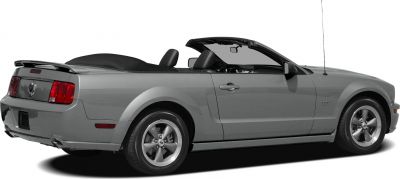 Side view of convertible Mustang with rear spoiler and alloy wheels