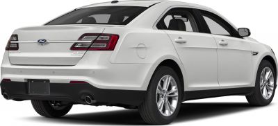 Rear three-quarter view of white sedan with dual exhaust and alloy wheels