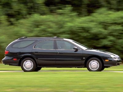 Side view of a black station wagon with roof rails in motion