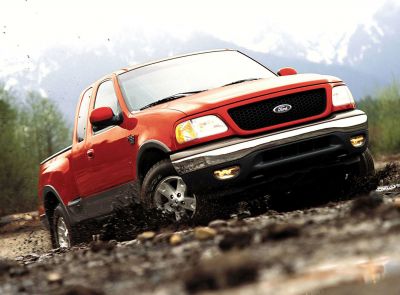 Off-road pickup in dynamic action with mud splash and bold front grille