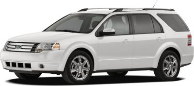 Front side view of white SUV with chrome wheels and roof rails
