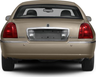 Rear view with tail lights, chrome bumper, and rear window of a luxury sedan