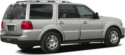 Silver large SUV with roof rack, rear tinted windows, and chrome wheels.
