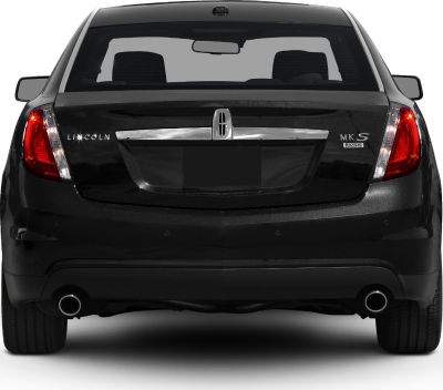 Rear view showcasing illuminated tail lights, chrome trim, and dual exhaust pipes
