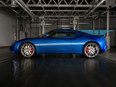 Side profile of a blue sports coupe with alloy wheels and red brake calipers